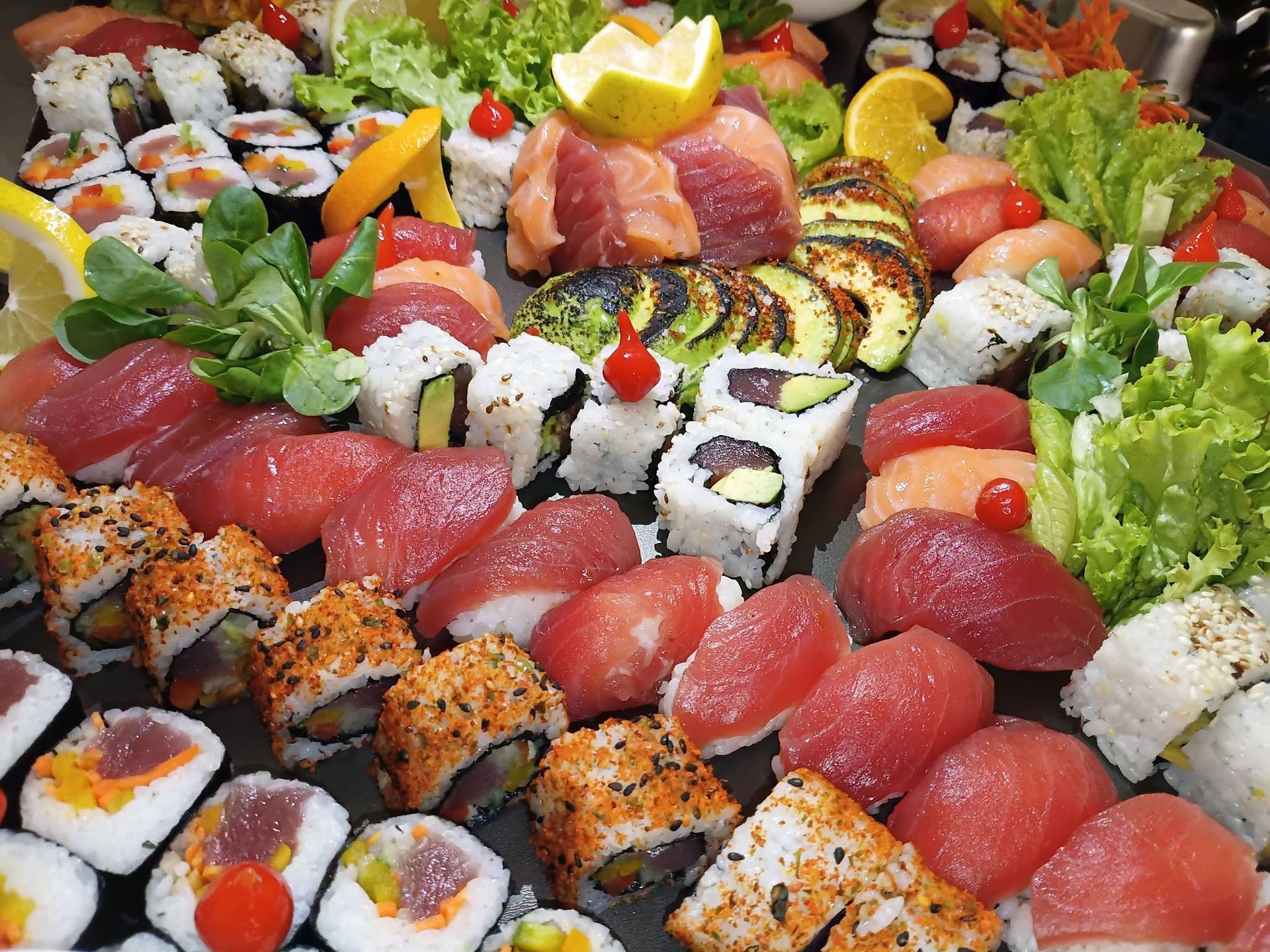 Assortiment de sushis au thon, de rouleaux et de citron, présenté sur un plateau de service