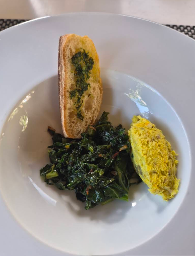 Entrée dressée avec du pain grillé, des légumes-feuilles et une purée jaune sur une assiette blanche