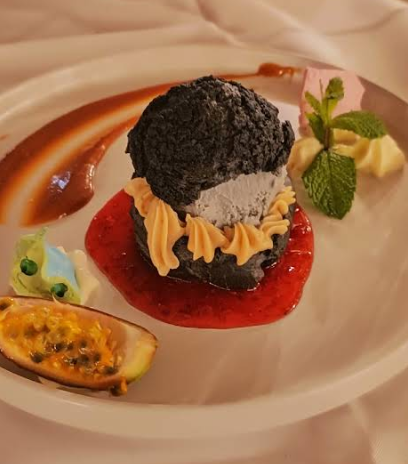 Assiette élégante de chou, de la sauce rouge, des feuilles de menthe et une garniture au fruit de la passion