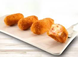 Cuatro croquetas doradas en un plato rectangular blanco. Una está parcialmente abierta, revelando un relleno cremoso.