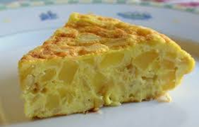 Una rebanada de tortilla de patata en un plato blanco. Es amarilla y se ven trozos de patata.
