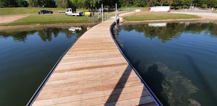 Ein Holzsteg führt über ein Gewässer.