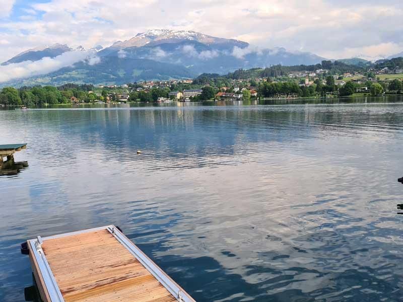 Ein Dock in der Mitte eines Sees mit Bergen im Hintergrund.