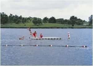 Eine Gruppe von Menschen schwimmt auf einem Floß in einem See.