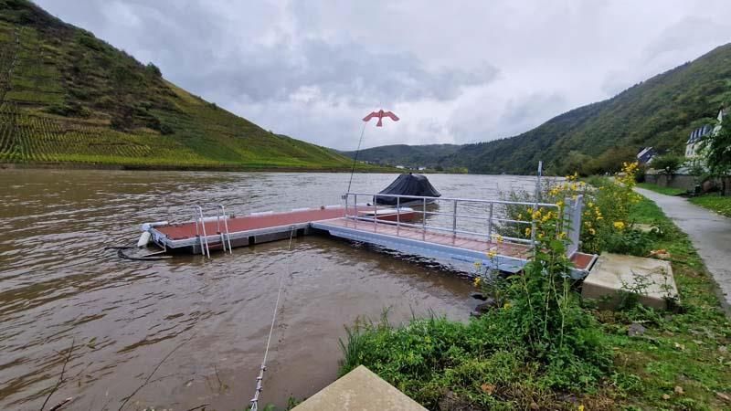 Ein Dock in der Mitte eines Sees mit Bergen im Hintergrund