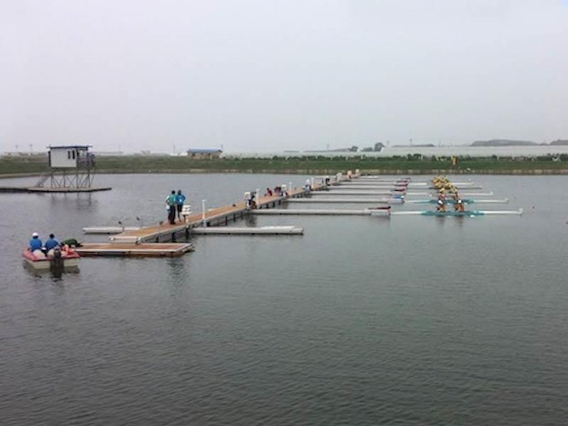 Eine Reihe Boote liegt an einem Steg in einem See.
