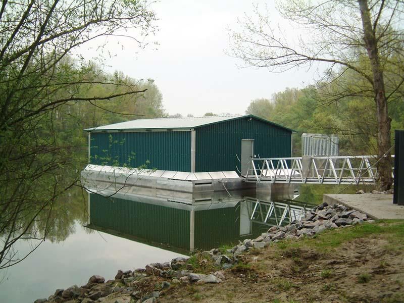 Ein grünes Gebäude steht am Ufer eines Gewässers