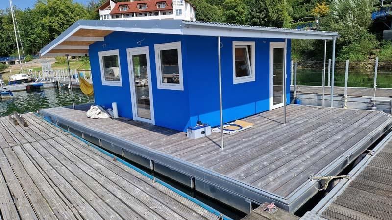 Ein blaues Haus steht auf einem Holzsteg