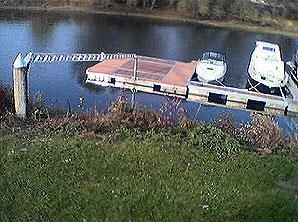 Zwei Boote liegen an einem Steg an einem See.