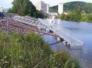 Eine Brücke über einen Fluss mit einem Lastwagen im Hintergrund.