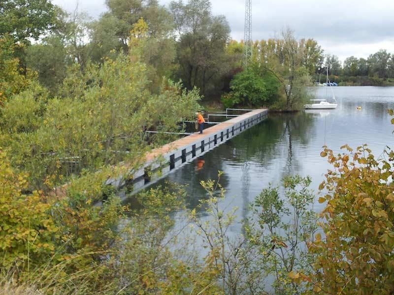 Eine Brücke über ein Gewässer, umgeben von Bäumen