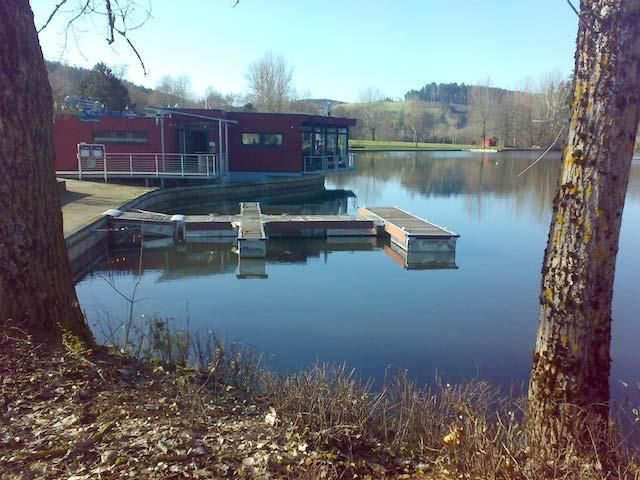Ein großes Gewässer mit einem Dock und einem Gebäude im Hintergrund