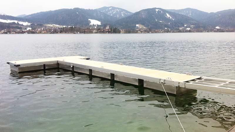 Ein Dock in der Mitte eines Sees mit Bergen im Hintergrund