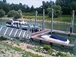 Ein Boot liegt an einem Dock neben einem Fluss.