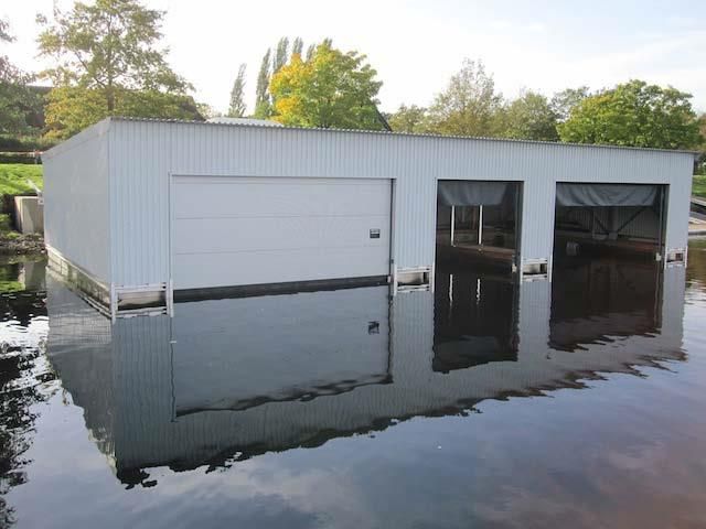 Eine weiße Garage ist von Hochwasser umgeben