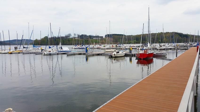 Ein Dock, das zu einem Yachthafen mit vielen angedockten Booten führt