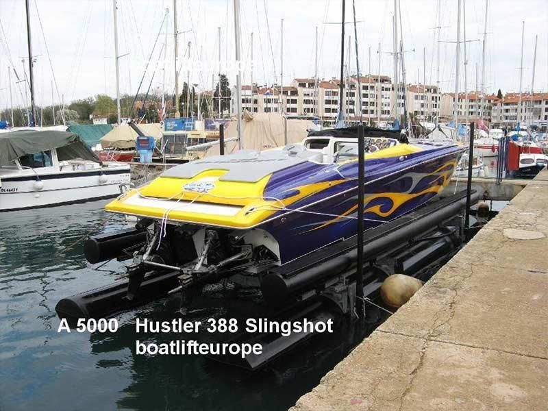 Ein lila und gelbes Boot wird von einem 5000 Hustler 388 Slingshot Boatlift Europe angehoben