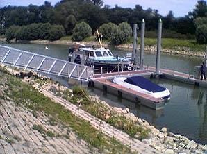 Ein Boot liegt an einem Dock an einem Fluss.