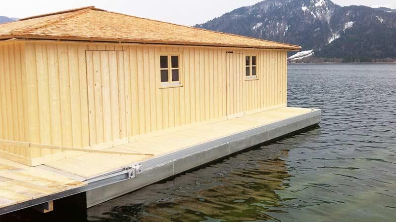 Ein Holzhaus schwimmt auf einer Wassermasse.