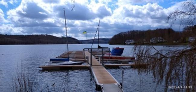 Ein Dock mit daran angedockten Booten in der Mitte eines Sees.