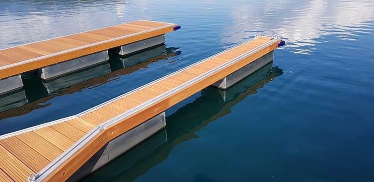 Ein Holzsteg schwimmt auf einer Wasserfläche.