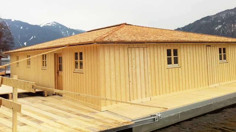 Ein Holzhaus wird mit Bergen im Hintergrund gebaut