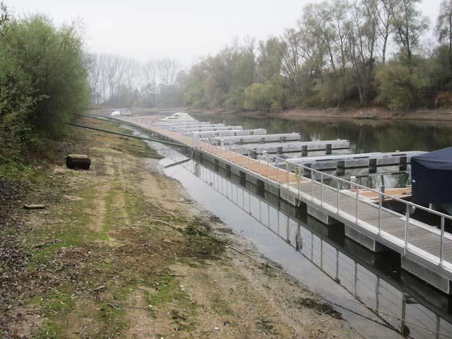 Ein Boot liegt an einem Dock am Ufer eines Flusses.