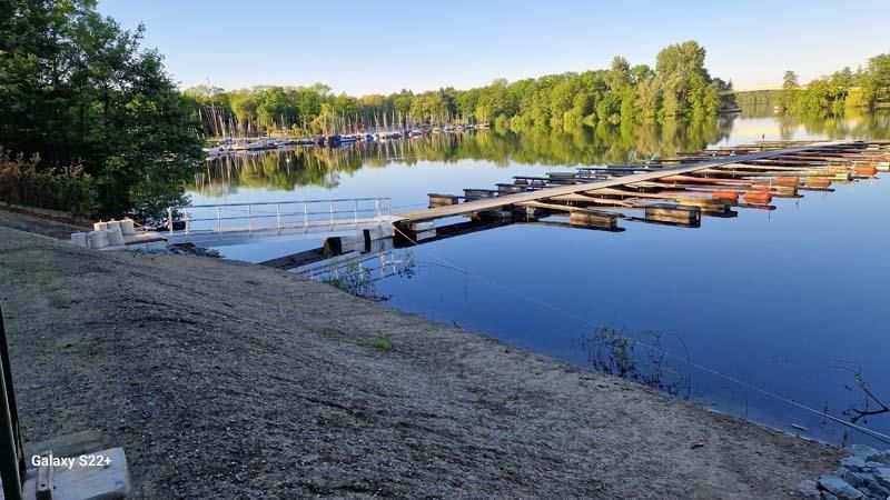 Eine Reihe Boote liegt am Ufer eines Sees vor Anker.