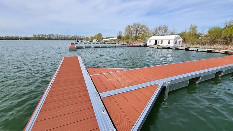 Ein Dock in der Mitte eines Sees mit einem Haus im Hintergrund
