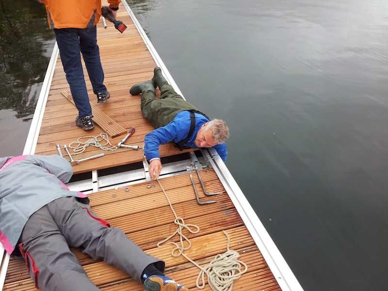 Ein Mann liegt auf einem Holzsteg in der Nähe des Wassers