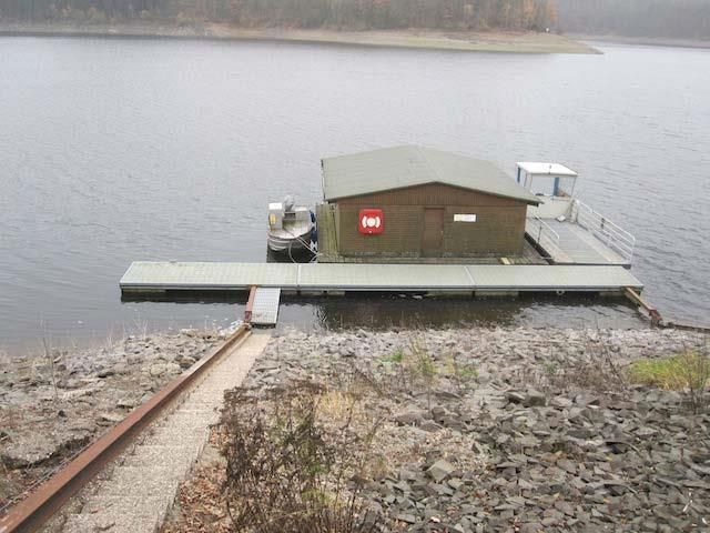 Ein Boot liegt an einem Steg mitten auf einem See.