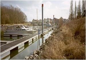 Ein Boot liegt an einem Dock neben einem Gewässer.