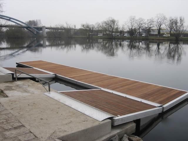 Ein Holzsteg mit einer Brücke im Hintergrund