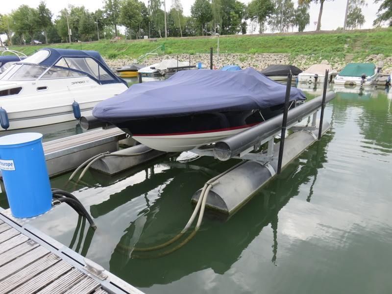 Ein Boot liegt auf einem Lift im Wasser