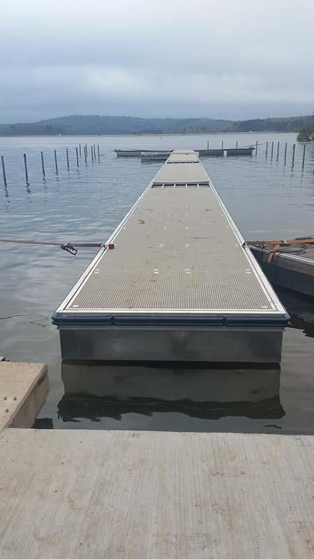 Ein langer Steg liegt mitten in einem Gewässer.