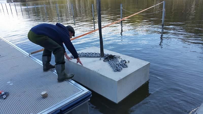 Ein Mann steht auf einem Dock in der Nähe eines Gewässers