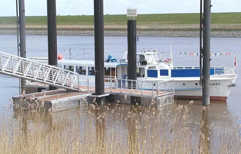 Ein blau-weißes Boot liegt an einem Dock