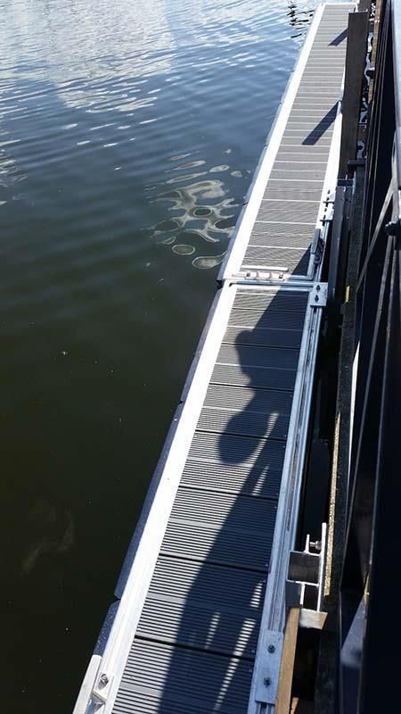 Ein Boot liegt an einem Steg im Wasser.