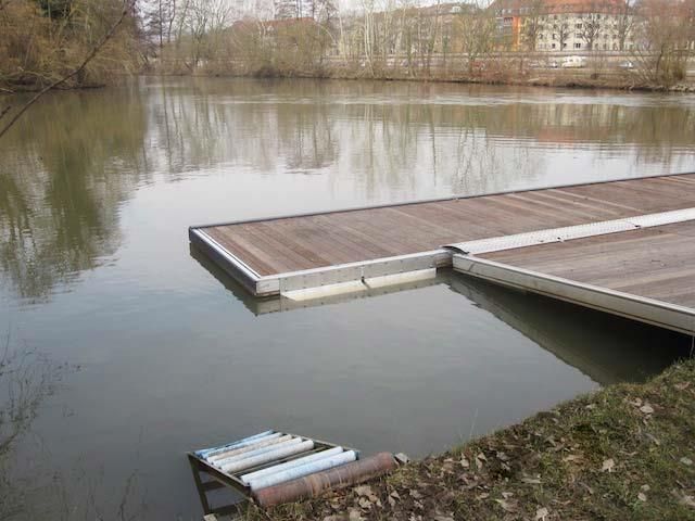 Am Ufer eines Sees liegt ein Holzsteg.