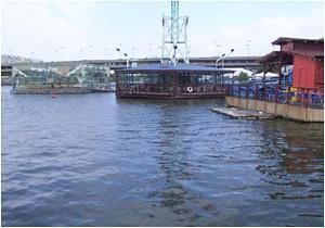 Ein großes Gewässer mit einer Brücke im Hintergrund.