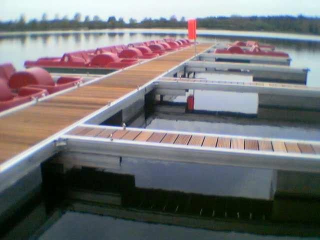 Ein Dock mit einem Haufen roter Tretboote darauf