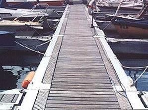 Ein Holzsteg, an dessen Ende Boote liegen.