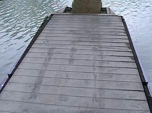 Ein Holzsteg, der in ein Gewässer führt.