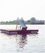 Auf einem Holzsteg mitten in einem See befindet sich eine Rutsche.