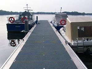 Zwei Boote liegen an einem Steg im Wasser