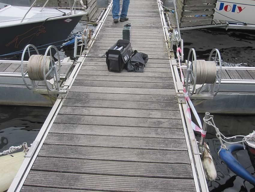 Eine Person, die auf einem Dock neben einem Boot läuft, auf dem „Jolly“ steht