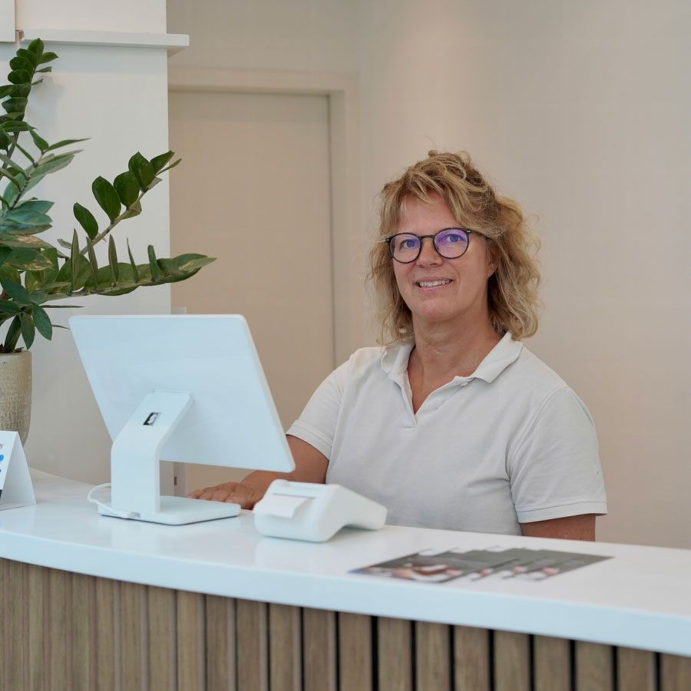 Ein Mann mit verschränkten Armen trägt ein weißes Hemd