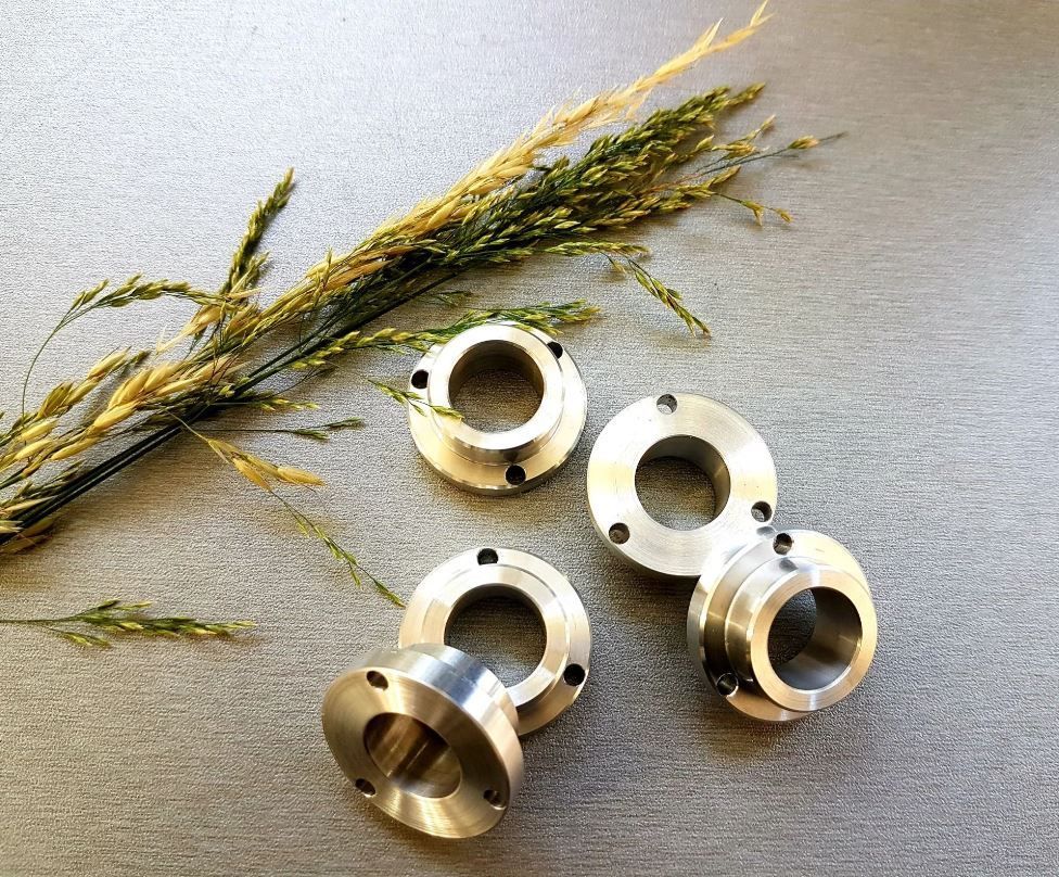 Une machine coupe un morceau de métal sur une photo en noir et blanc.