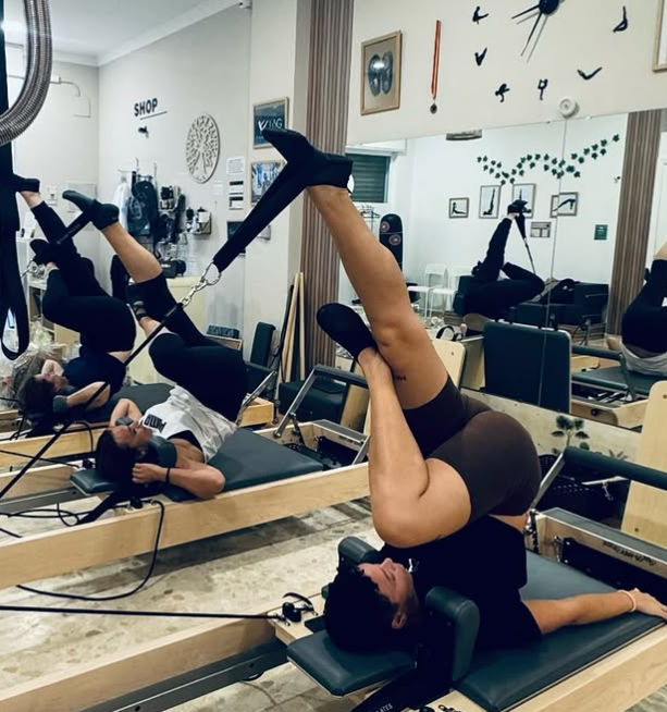 Un grupo de personas está haciendo ejercicios de pilates en un gimnasio.