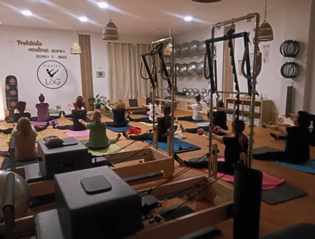 Un grupo de personas está haciendo pilates en un gimnasio.